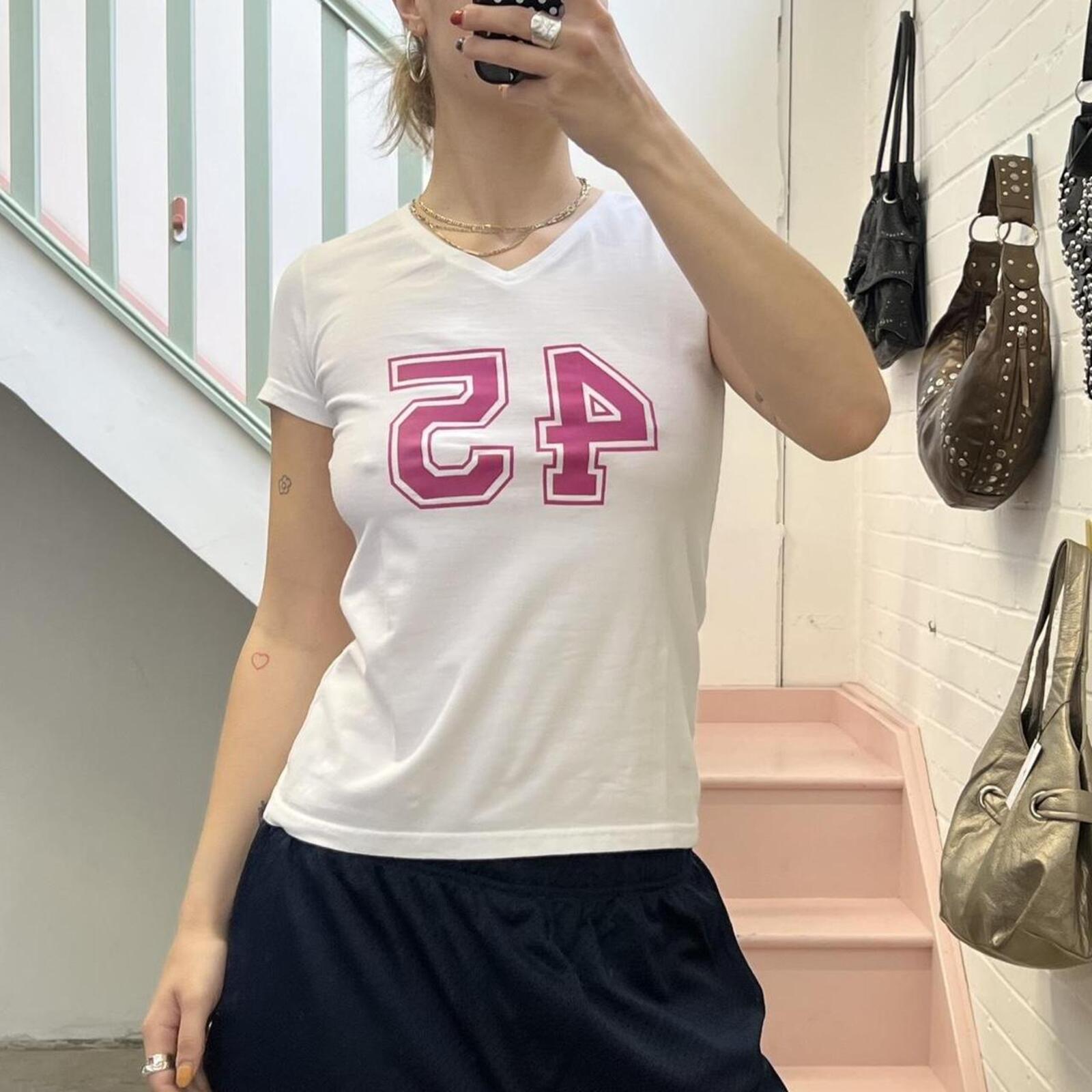 White fitted v neck baby tee with pink number print