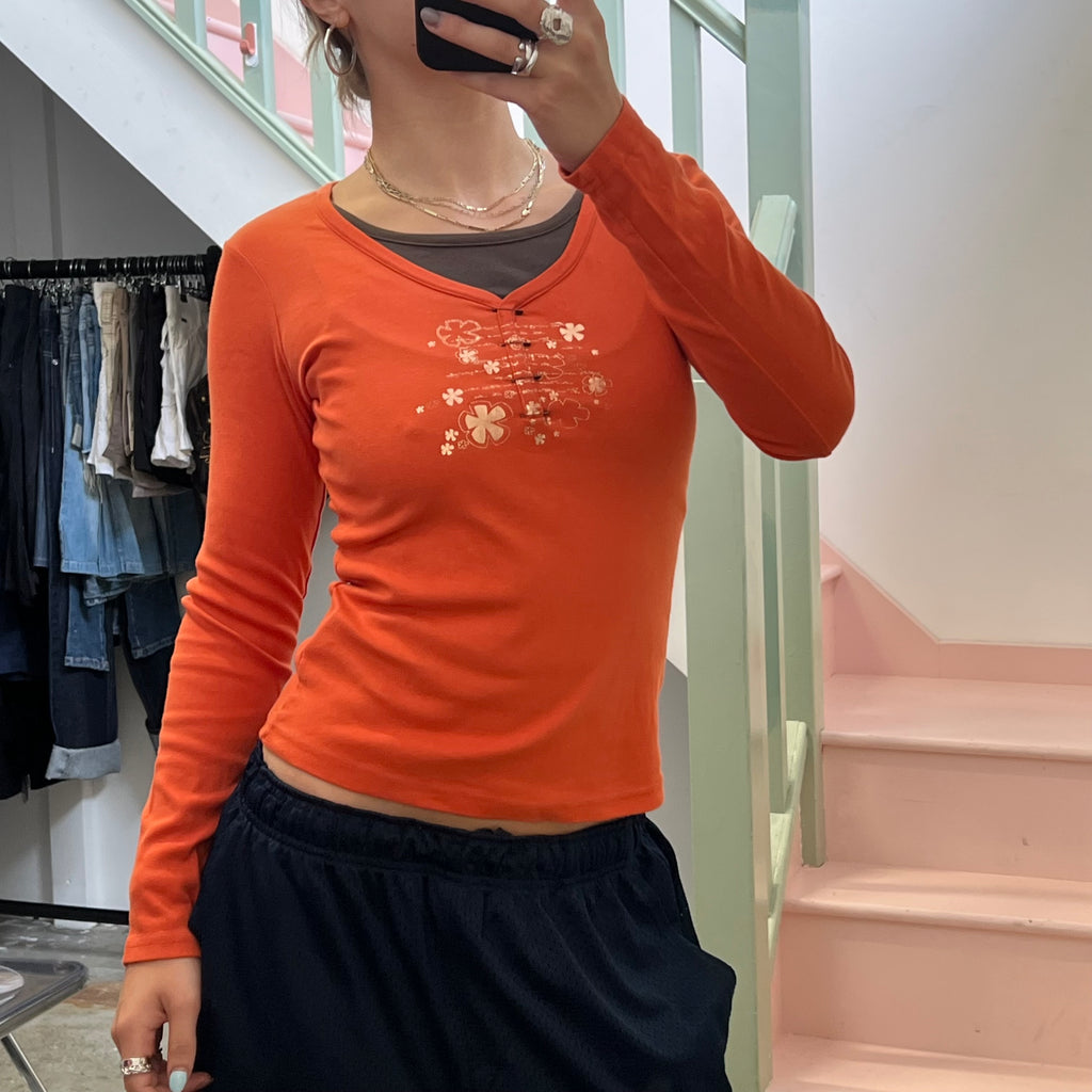 Cache orange top with pin detail