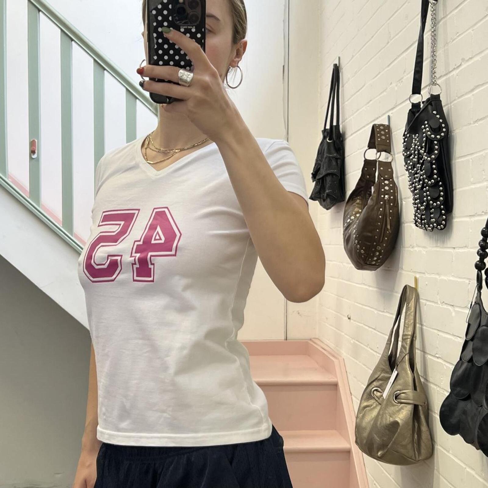White fitted v neck baby tee with pink number print
