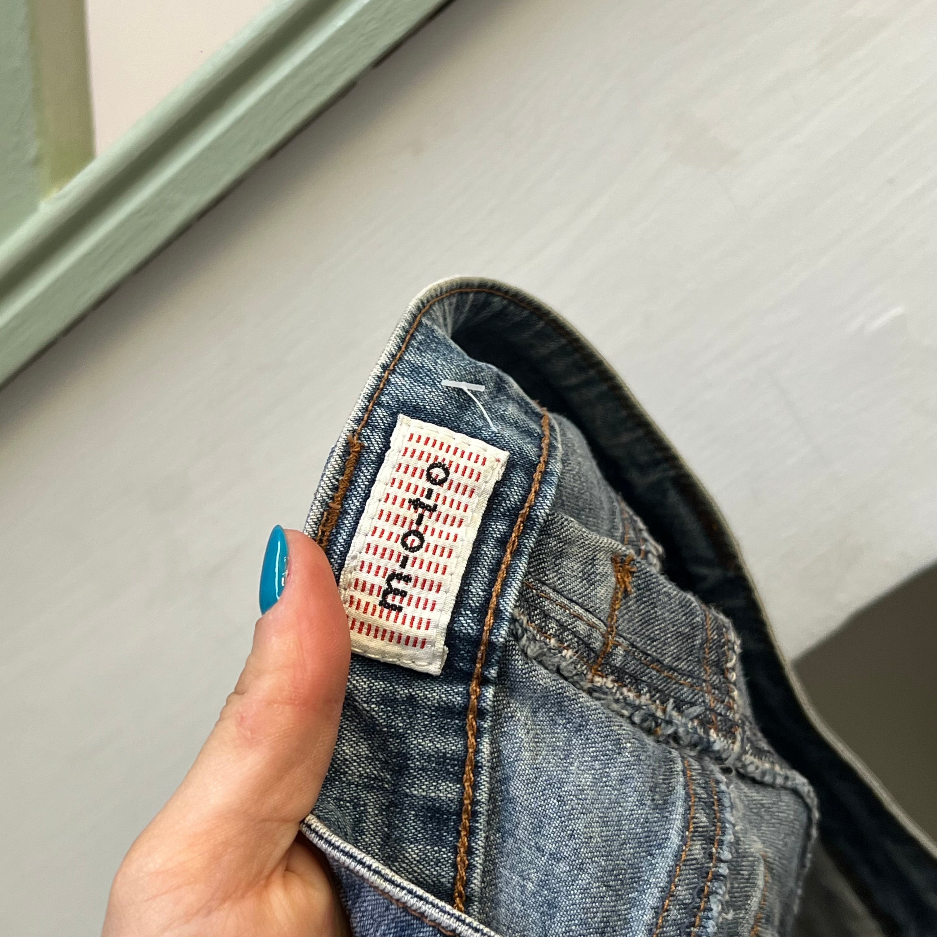 Mid wash fitted denim capris with buckle detail