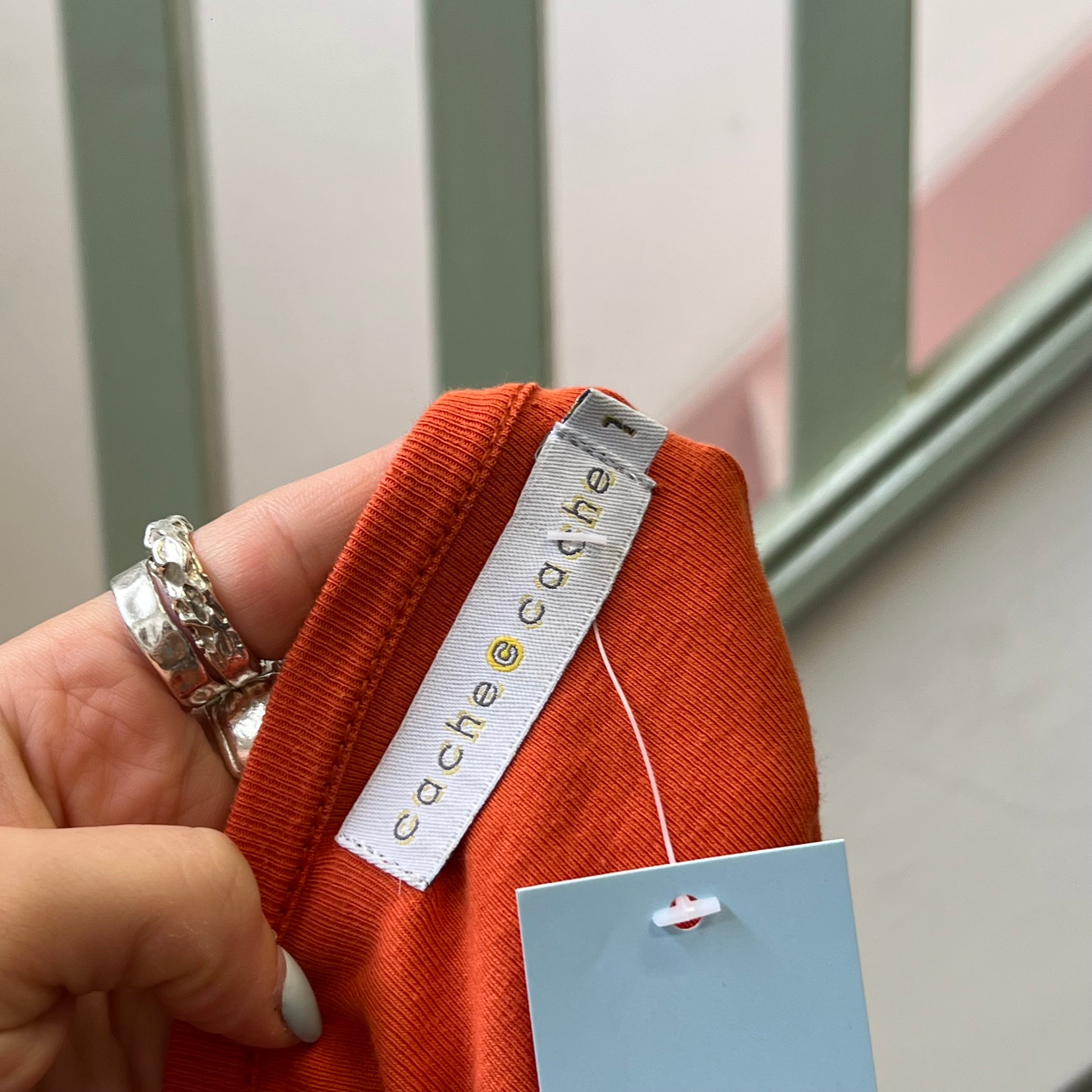 Cache orange top with pin detail